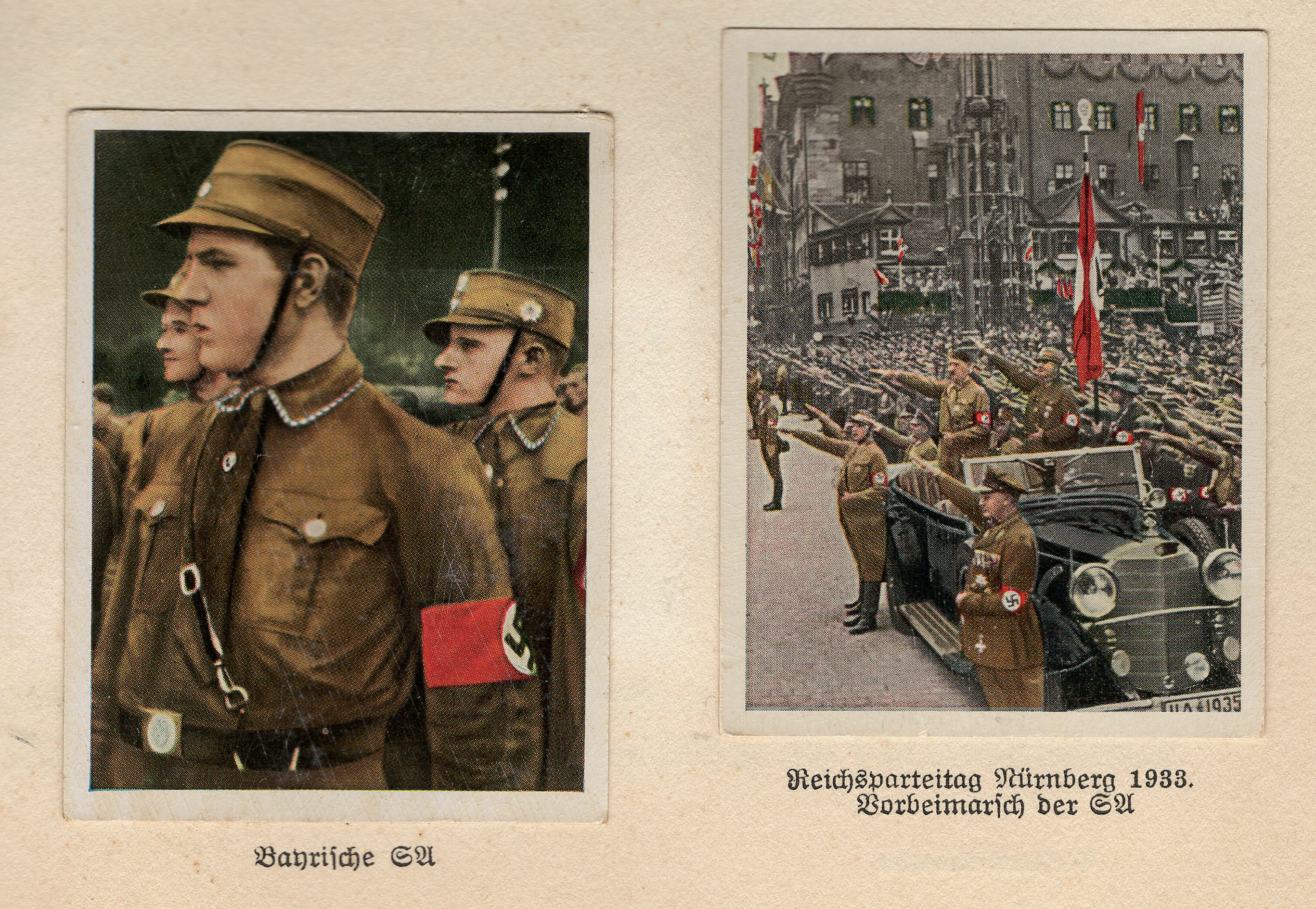 A detail shot of two collectable cards pasted into a book. The book’s text is in German, with a highly angular Gothic font. The left image is a close-up of a Nazi brownshirt. The right image shows a large crowd performing the Nazi salute, with Adolf Hitler also giving the salute, standing in front of the crowd in a convertible car.